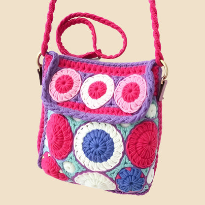 Colorful crochet bag with owl design on a pink background