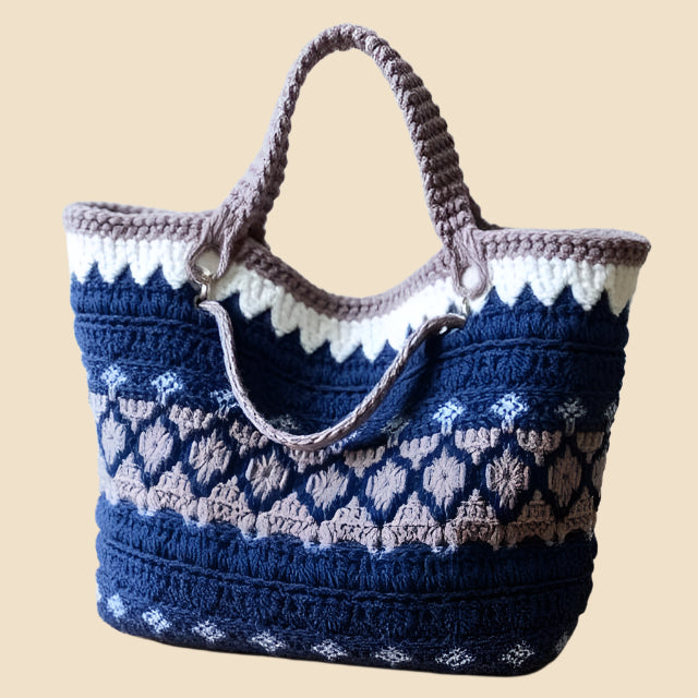 Blue, grey and white crochet tote with circular patterns on a pink background